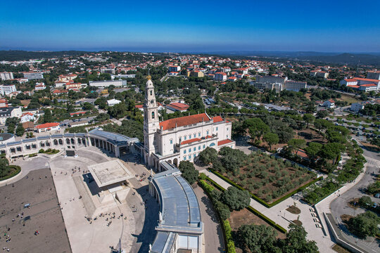 Aerial view of the Sanctuary of Our Lady of Fatima with its iconic basilica, expansive square, and colonnades surrounded by the town of Fatima, Santarem District, Portugal.