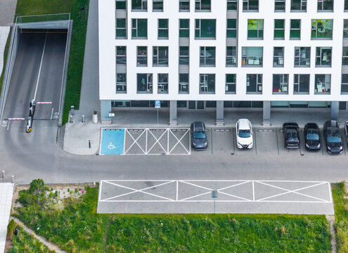 Aerial view of the Olivia Business Centre featuring modern office architecture, a parking lot with marked spaces, and an underground garage entrance in Gdansk, Pomeranian Voivodeship, Poland.