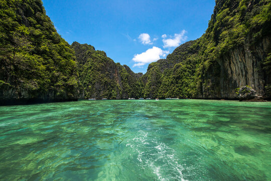 Aerial view of Pi Leh Bay featuring crystal clear turquoise waters surrounded by towering limestone cliffs and lush tropical vegetation in Tambon Ao Nang, Chang Wat Krabi, Thailand.