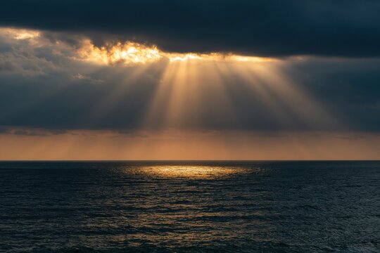 Sunbeams breaking through dramatic clouds over the ocean
