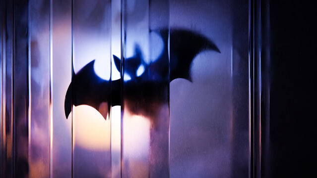 Halloween bat silhouette seen through reflective vertical glass layers.
