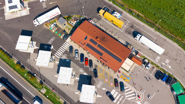 San Giuliano Milanese, Italy - 04 September 2026: Aerial view of the Q8 gas station with parked trucks, cars, and solar panels on the roof.