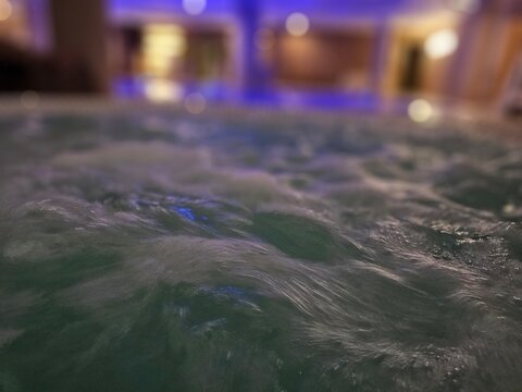 Water ripples in a pool setting with blue lighting reflecting