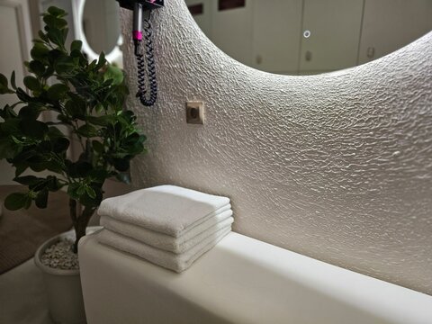 Towels arranged neatly on a table near a plant