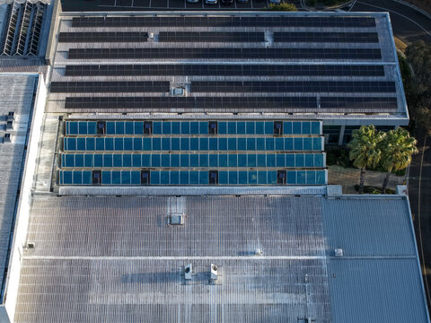 Wantirna South, Australia - 03 September 2026: Aerial view of a commercial building roof featuring extensive solar panel arrays and glass skylights.