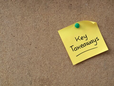 Key Takeaways text handwritten on yellow adhesive note pinned with a green push pin on a brown cork board. Ideal for business summaries, educational points, strategies, and learning concepts