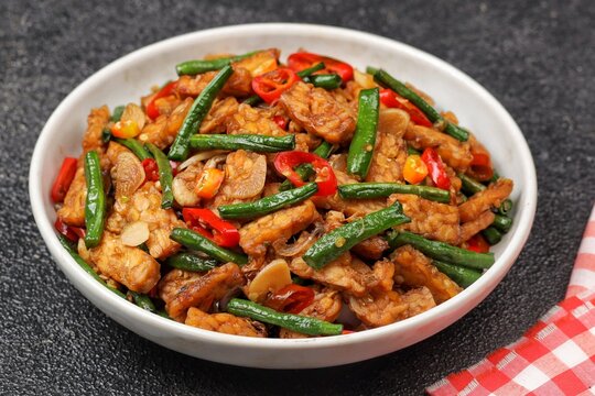 oseng tempe kacang panjang or stir-fried tempeh with long beans, cooked with garlic, shallots, chilies, and savory seasonings.