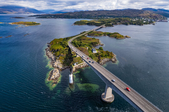 Isle of Skye, United Kingdom - 02 September 2023: Aerial view of Skye Bridge spanning the water with cars driving across, surrounded by rocky islands and coastal scenery.