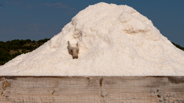 Large pile of sea salt at a traditional saltworks under blue sky