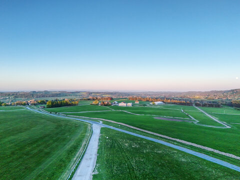 Middleham, England, United Kingdom - 30 April 2026: Aerial view of Middleham surrounded by lush green fields, winding country roads, and rolling hills under a clear blue sky.