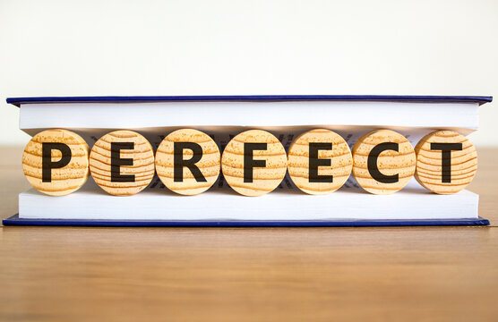 Perfect word symbol. Concept word Perfect on beautiful wooden circles in book. Beautiful wooden table white background. Business perfect word concept. Copy space.