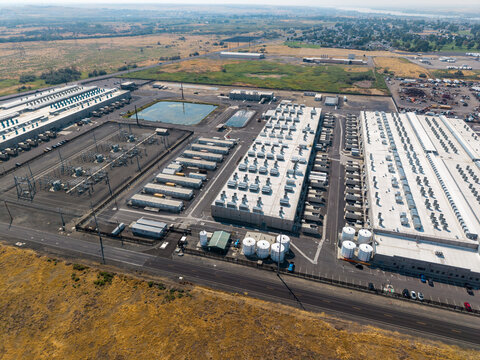 Umatilla, United States - 15 August 2026: Aerial view of the Amazon Web Services data center with industrial buildings, cooling units, electrical substations, and arid landscape.