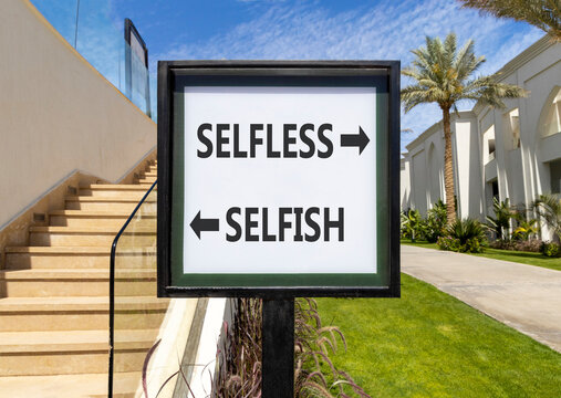 Selfless instead selfish words symbol. Concept words Selfless Selfish on beautiful white road sign. Beautiful palm trees background. Business medical psychology selfless selfish concept. Copy space.