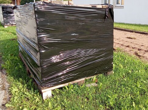 Shrink Wrapped Paving Slab Pallet on Sidewalk Construction Site
