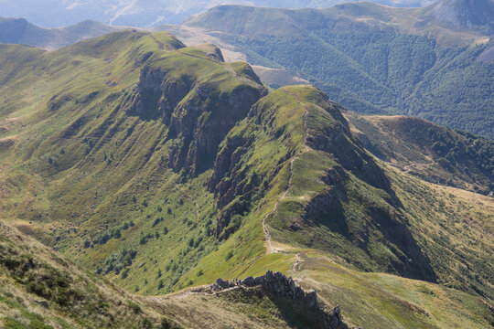 chemin de Randonn&eacute;e en &eacute;t&eacute; dans le Cantal, sentier de randonn&eacute;e entre le Puy Mary et la br&egrave;che de Rolland avec panorama sur les sommets cantaliens	
