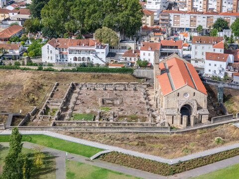 Coimbra, Portugal - 27 August 2026: Aerial view of Mosteiro de Santa Clara-a-Velha showing the historic stone ruins and the preserved church building with its red-tiled roof.