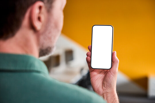 Man holds a smartphone with a blank screen in the office