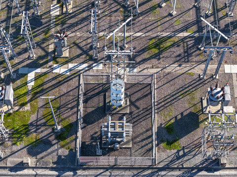 Bayswater North, Australia - 29 August 2026: Aerial view of Bayswater Zone Substation with electrical transformers, metal structures, and power lines casting long shadows on gravel.