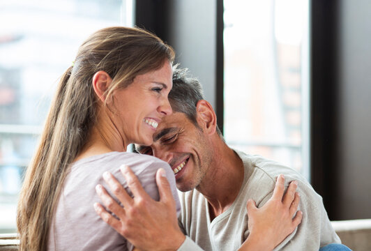 Happy man and woman hug each other in the living room