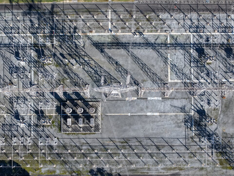 Ringwood, Australia - 29 August 2026: Aerial view of Ringwood Terminal Station with electrical transformers, high-voltage towers, and metal structures casting long shadows.