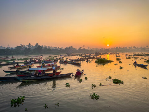View of Lok Baintan Floating Market with traditional wooden boats filled with vendors on the river at sunrise in Sungai Tabuk, South Kalimantan, Indonesia.