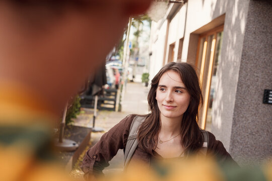 A young woman talks with a man on the city street