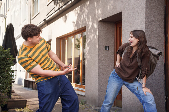 A man and a woman share a joke on a city street