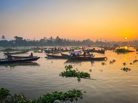 View of Lok Baintan Floating Market with traditional wooden boats carrying traders on the river at sunrise in Sungai Tabuk, South Kalimantan, Indonesia.