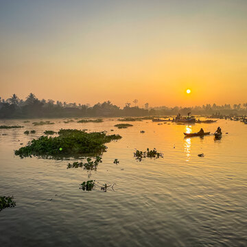 View of Lok Baintan Floating Market with traditional wooden boats on the river at sunrise in Sungai Tabuk, South Kalimantan, Indonesia.