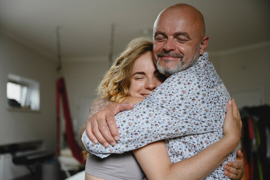 A happy father hugs his young daughter at home