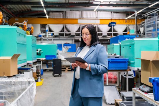 Businesswoman using digital tablet in production hall