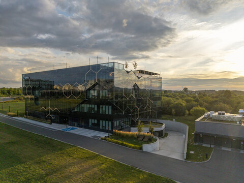 Krakow, Malopolska, Poland - 18 August 2026: Aerial view of Selvita headquarters featuring a modern glass facade with a honeycomb pattern during sunset.