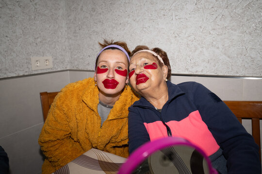 Senior woman and young woman wear funny collagen patches indoors