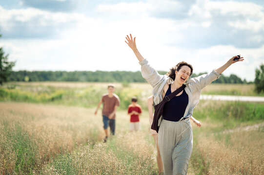 Happy mature woman walking in a field with her family