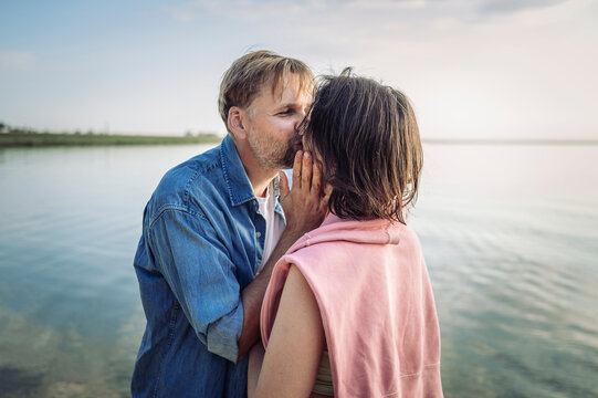 A loving man and woman kiss at the beach during summer vacation