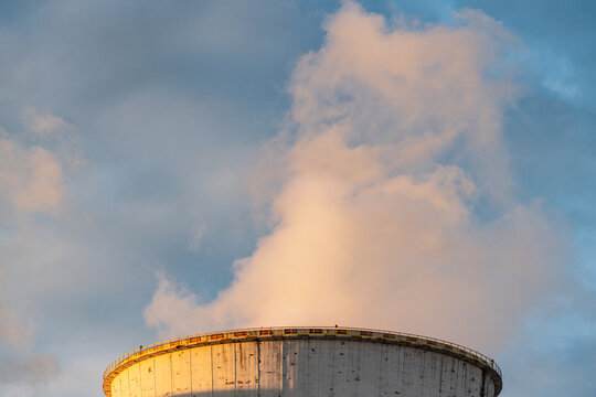 View of the cooling tower at the Jaworzno power plant emitting steam into the blue sky at sunset in Jaworzno, Silesian Voivodeship, Poland.