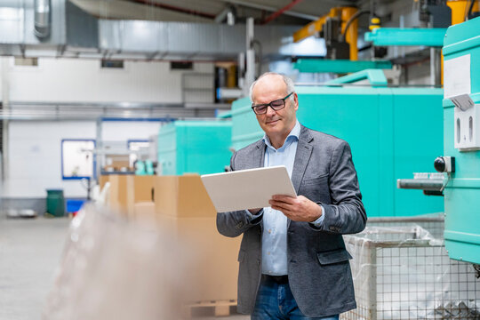 Manager checks production planning on a tablet in the factory