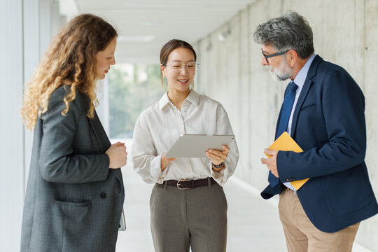 Business people discuss a project on a digital tablet at the office