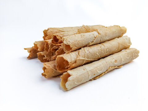Close-up of (semprong in Indonesia) crispy rolled wafer cookies stacked together and isolated on a clean white background