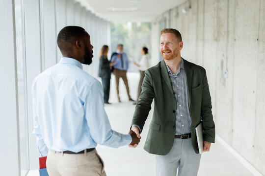 Two businessmen shake hands in a modern office