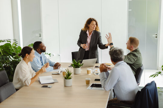 Businesswoman gives high five to man during corporate meeting