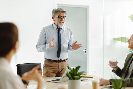 A businessman gives a presentation to colleagues in the office