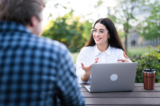 Businesswoman discusses strategy with a male colleague outdoors