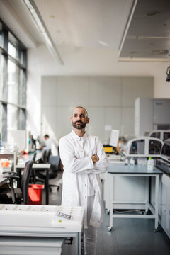 Confident male scientist stands in a modern research laboratory