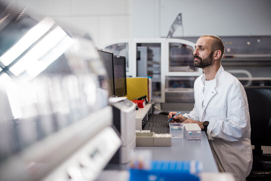 Male scientist working on computer in high-tech laboratory