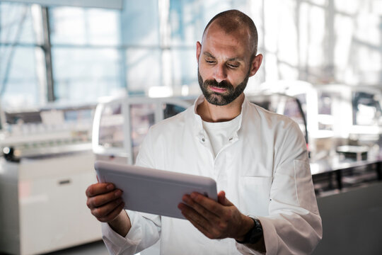 Male scientist holds a tablet in a high tech laboratory