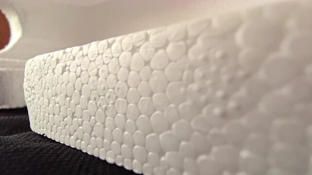 Detailed macro shot of a white styrofoam block corner edge with shallow depth of field. Ideal for product packaging and 3D material close-ups.