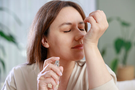 Woman applying perfume to wrist