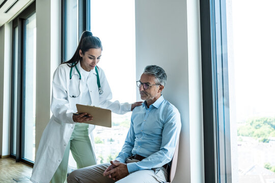 Female doctor gives medical advice to a male patient in the hospital