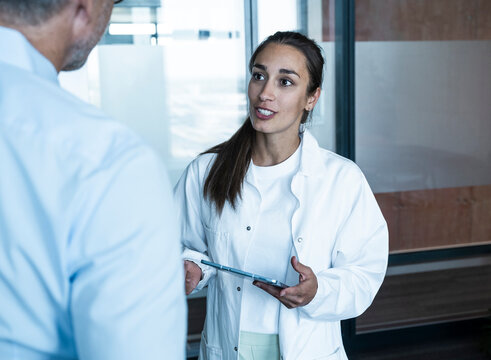 Female doctor with tablet advising male patient at medical practice